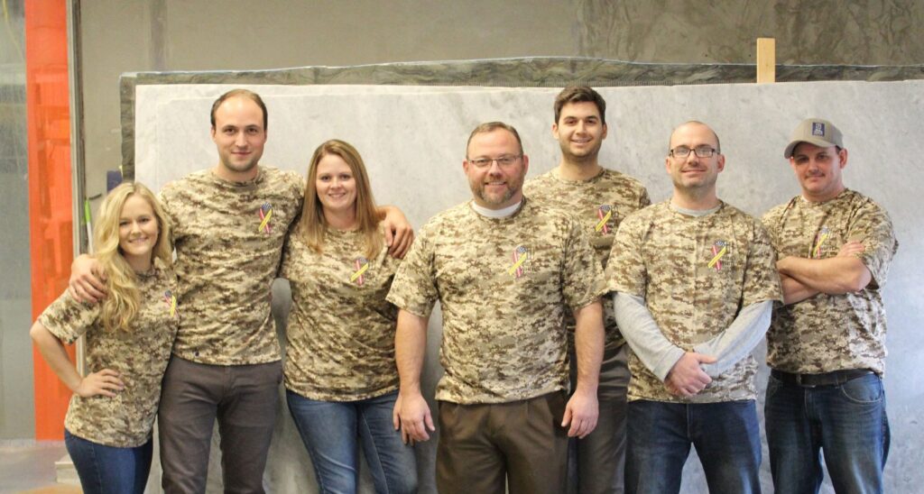 Paul White Company employees wearing camouflage t-shirts in support of U.S. troops; in the Portland, Maine stone shop